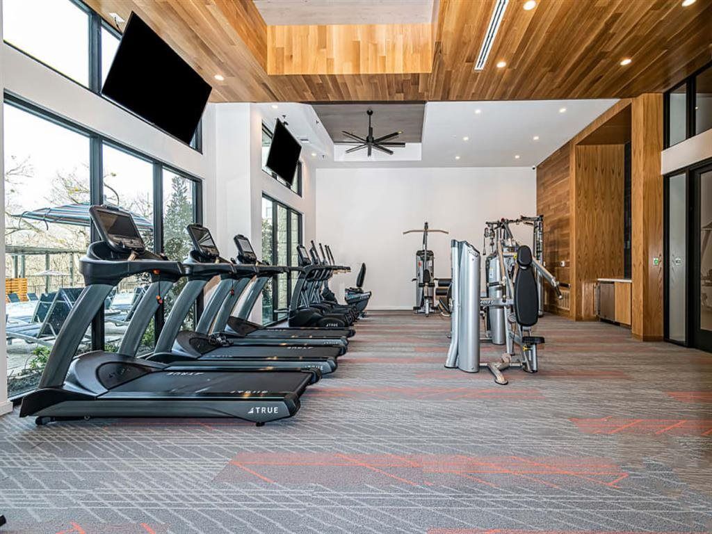 A large gym with a lot of treadmills and exercise equipment.