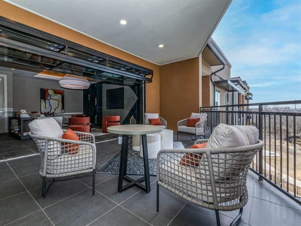 There is a balcony with a table and chairs on it.