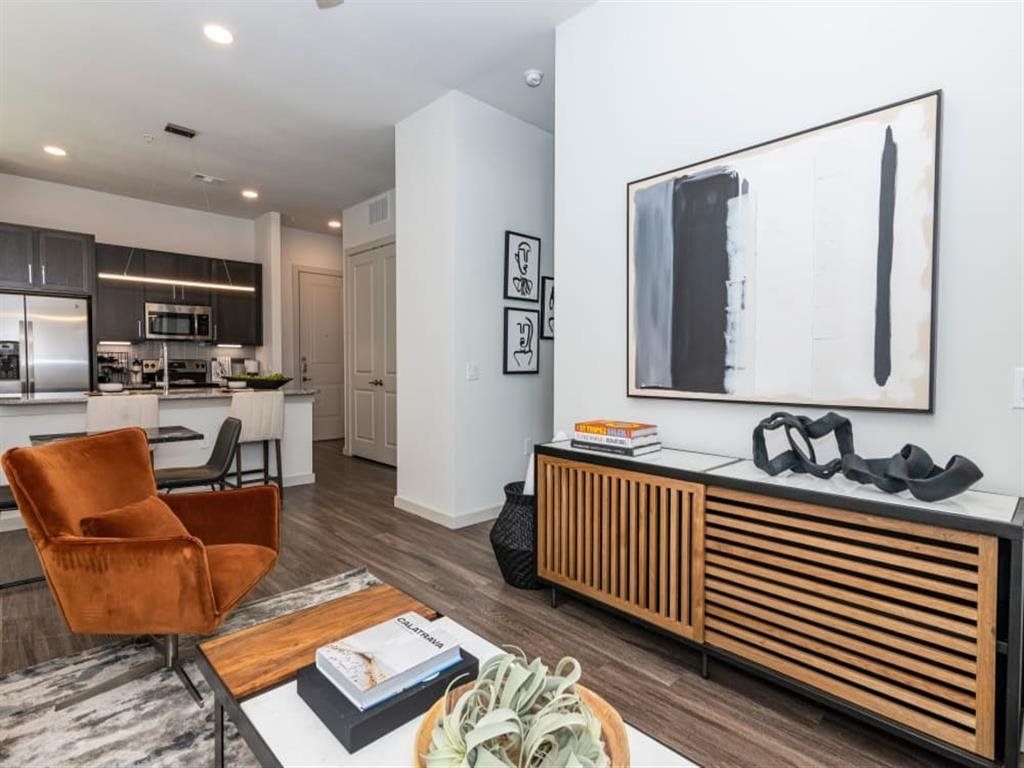 A living room with a chair , coffee table , and television.