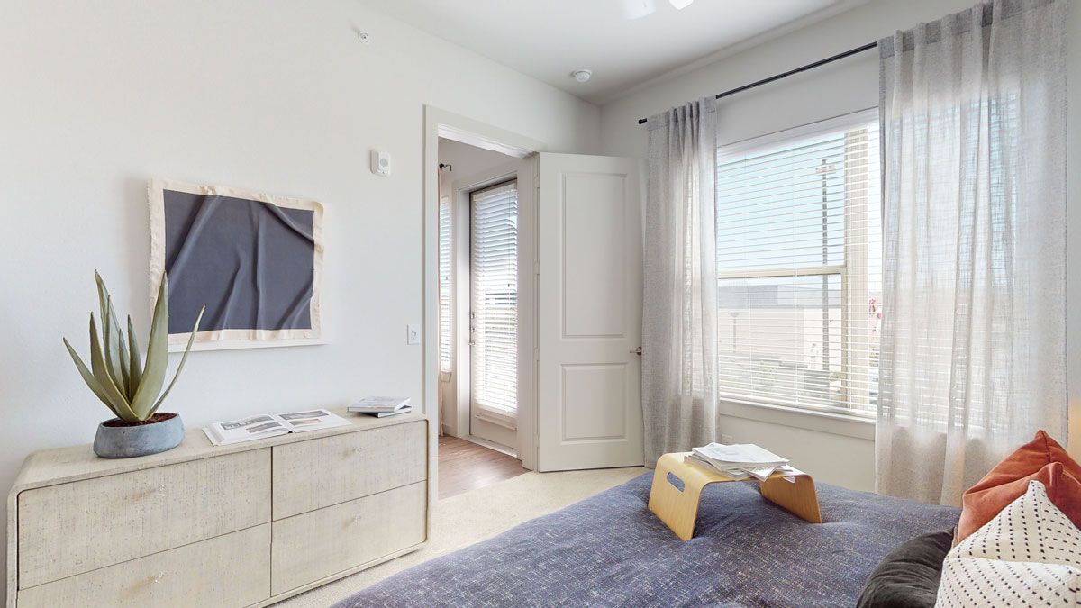 A bedroom with a large bed and a mirror on the wall.