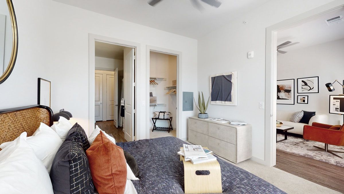 A bedroom with a large bed and a mirror on the wall.