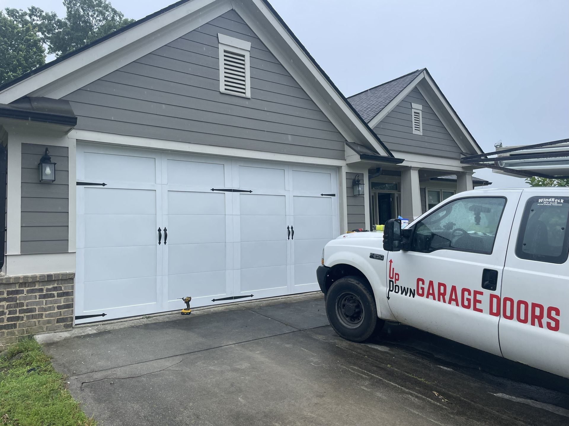 White garage door on a house; white truck with