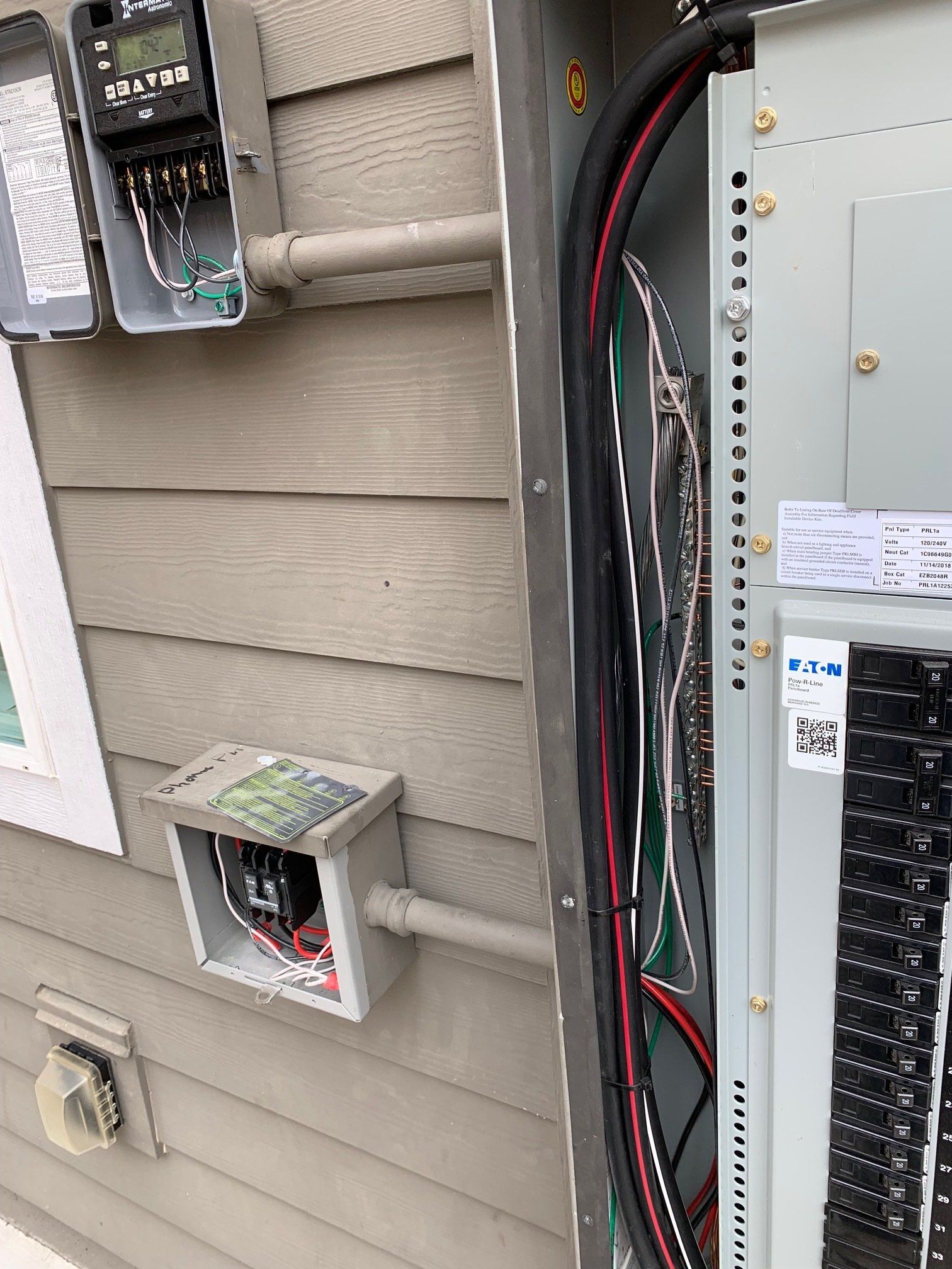A close up of an electrical box on the side of a house.