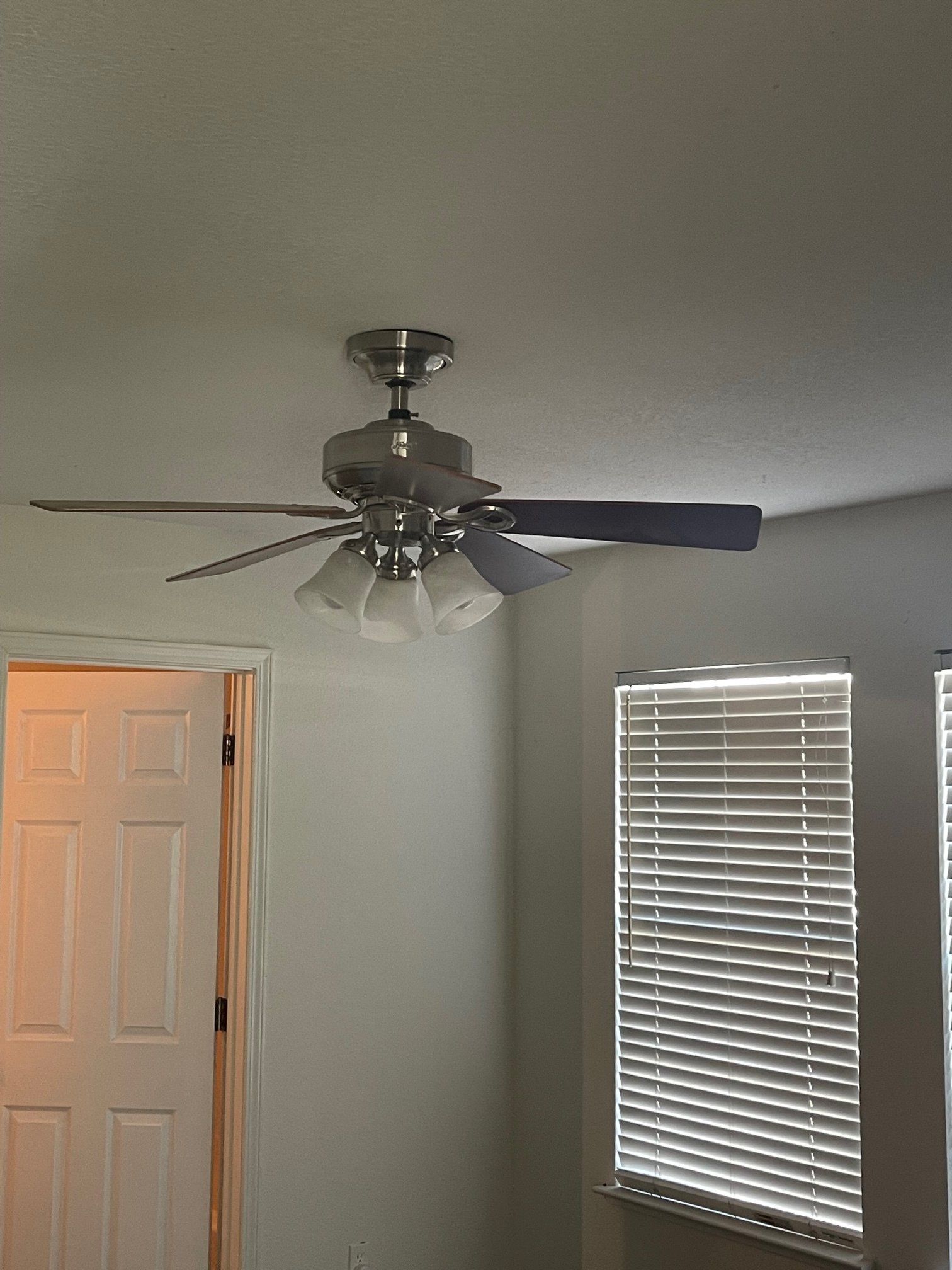 There is a ceiling fan in the corner of the room.