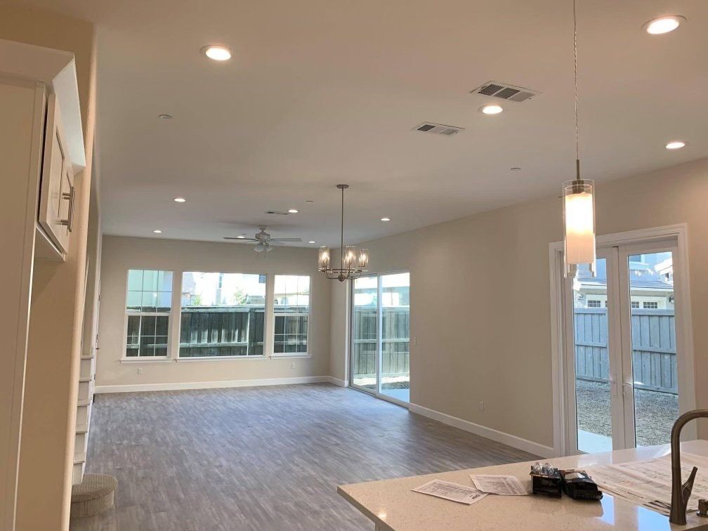 A large empty room with a chandelier hanging from the ceiling.