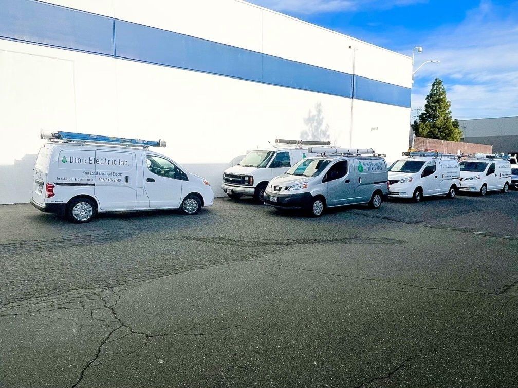 A row of white vans are parked in front of a building.
