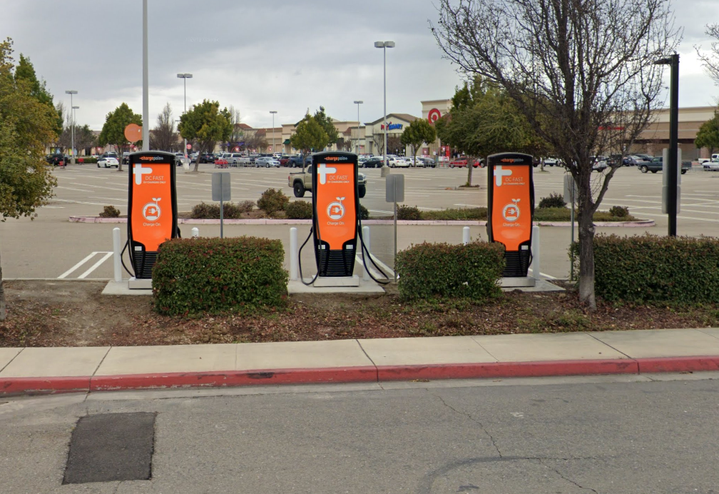 three orange charging stations in a parking lot