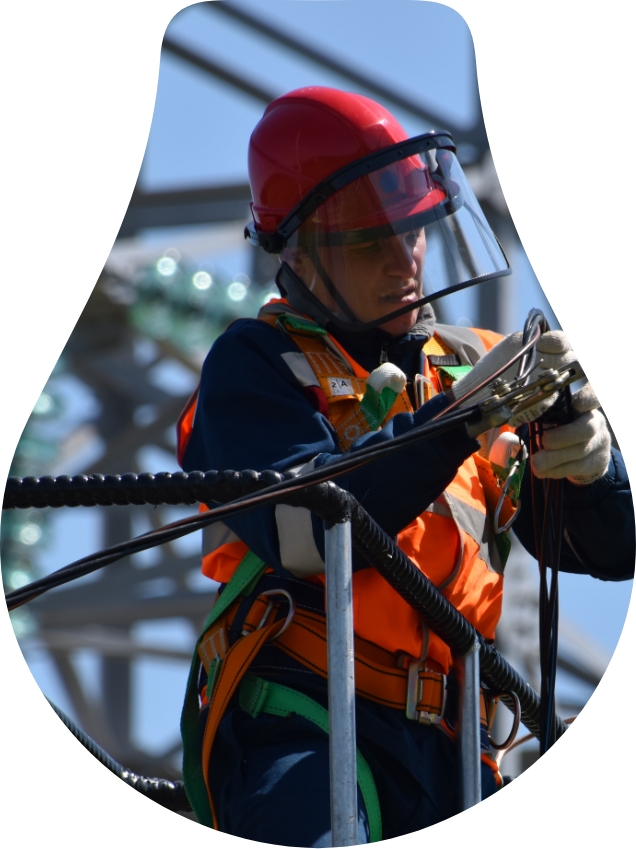 A man wearing a helmet and safety gear is working on a rope