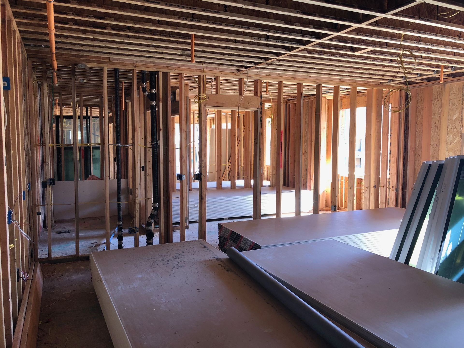 A room in a house under construction with a lot of wooden beams.