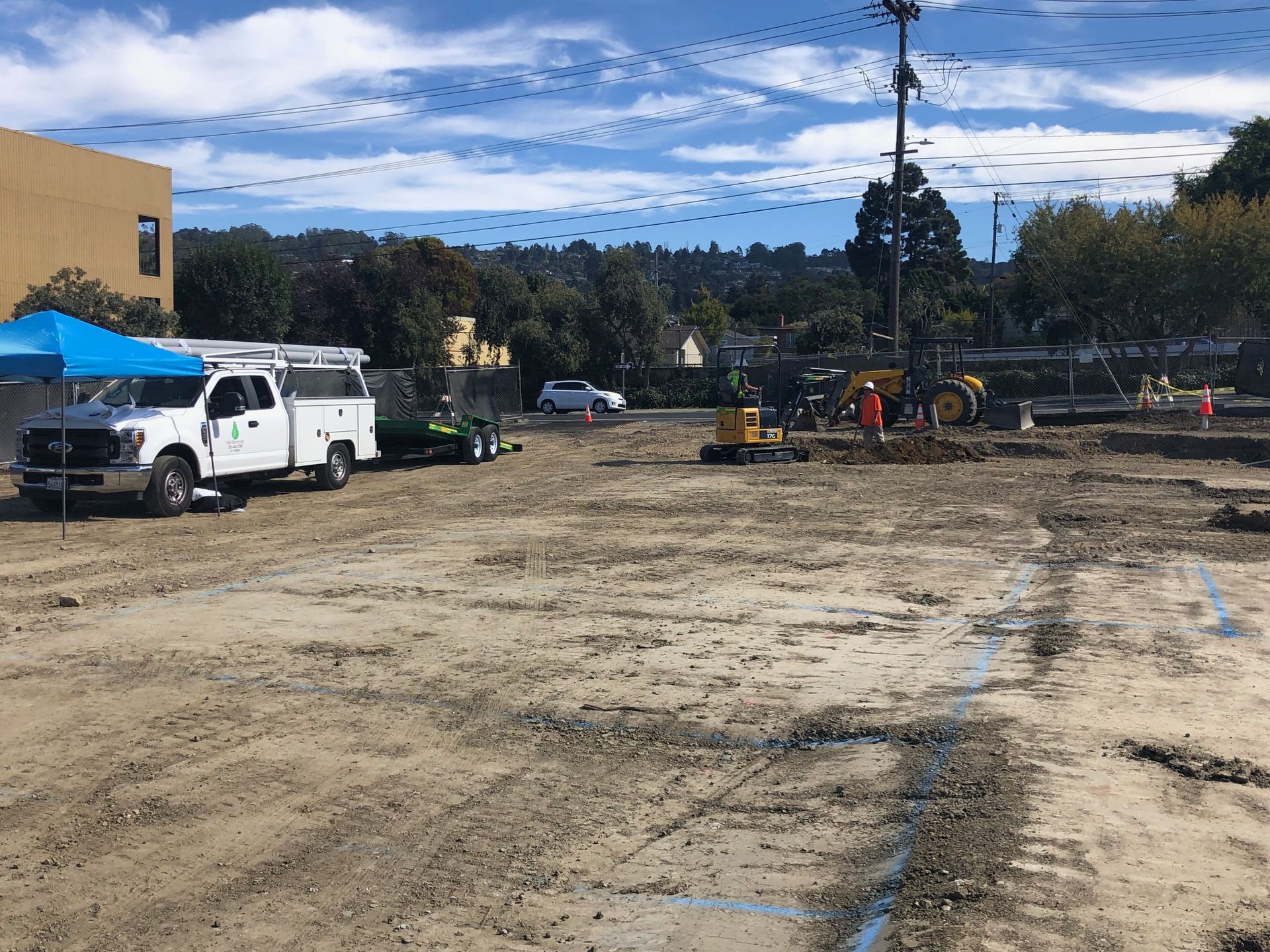 A white truck is parked in the middle of a dirt field.