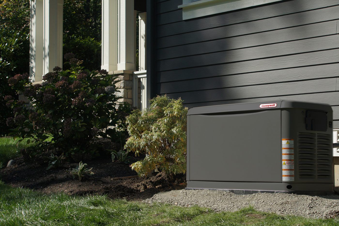 A generator is sitting on the side of a house.