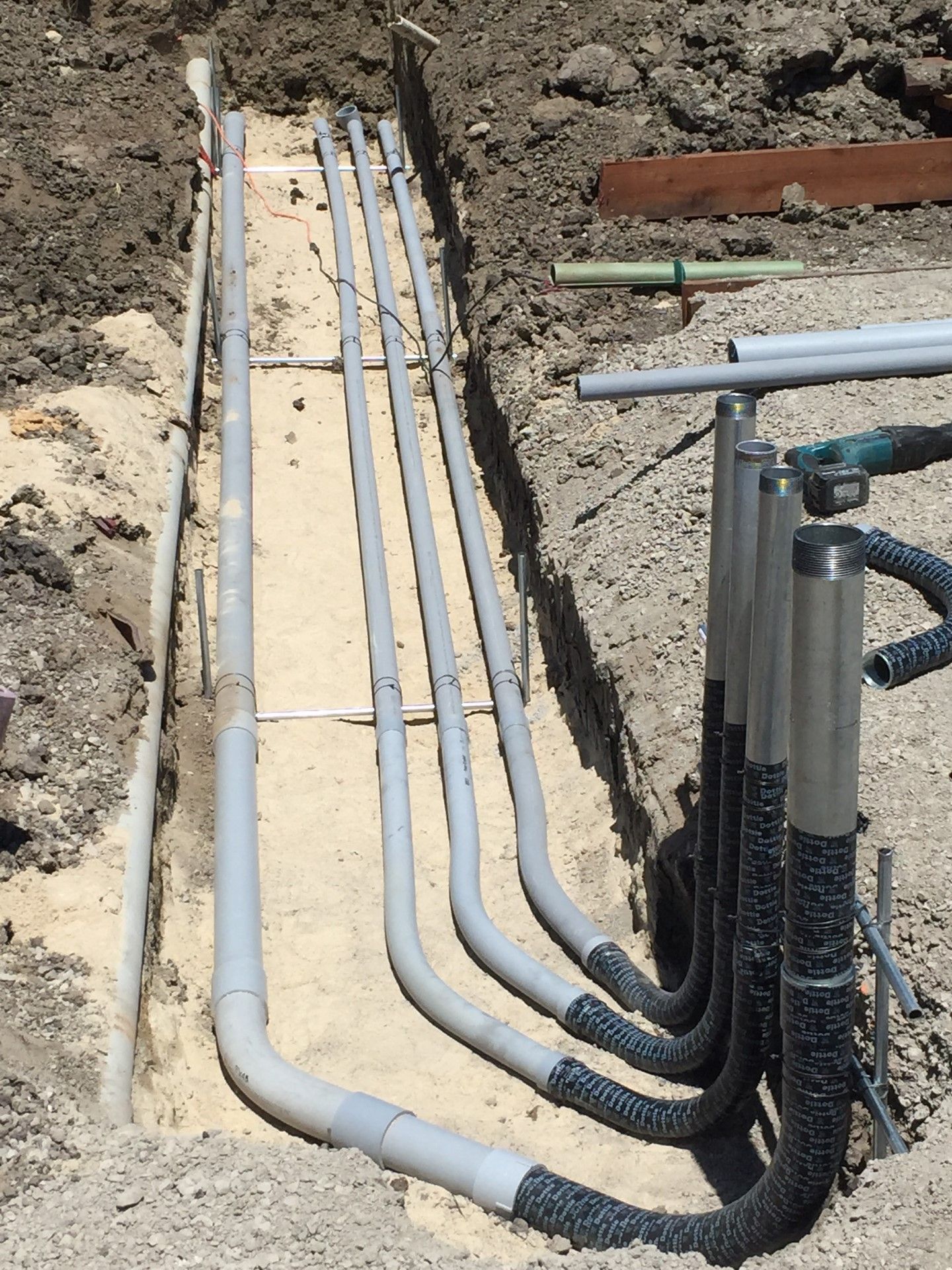 A bunch of pipes are being installed in the dirt.