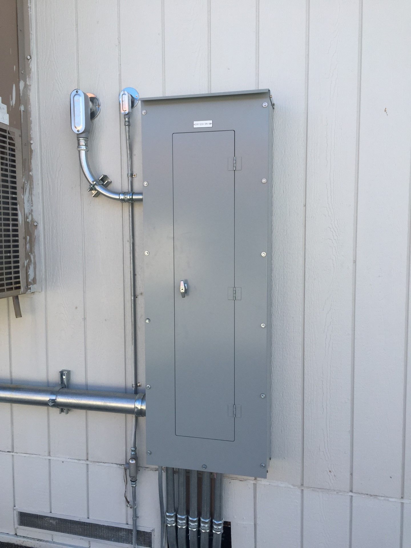 An electrical box is attached to the side of a building.