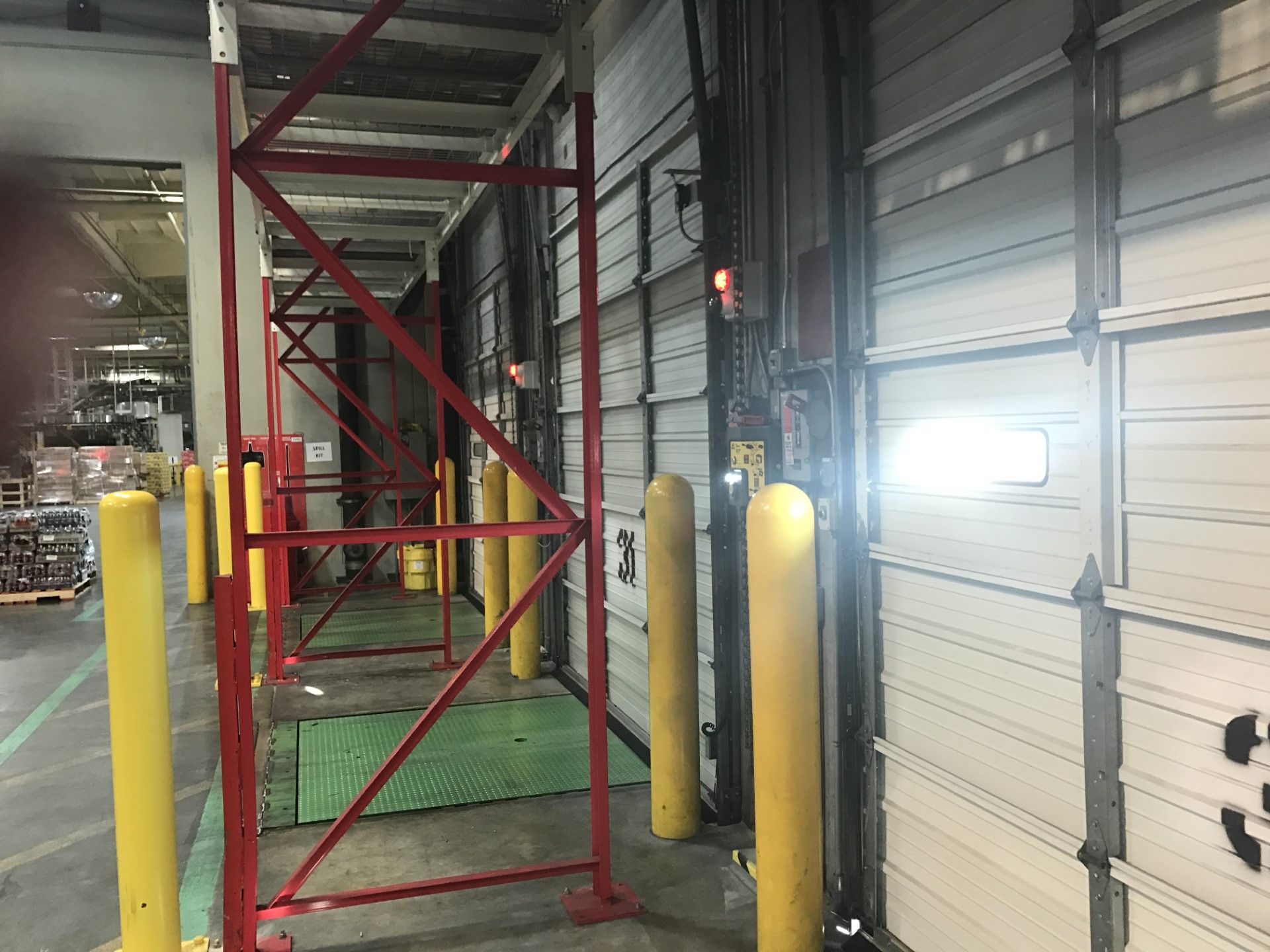 A warehouse with a red shelf and yellow poles.