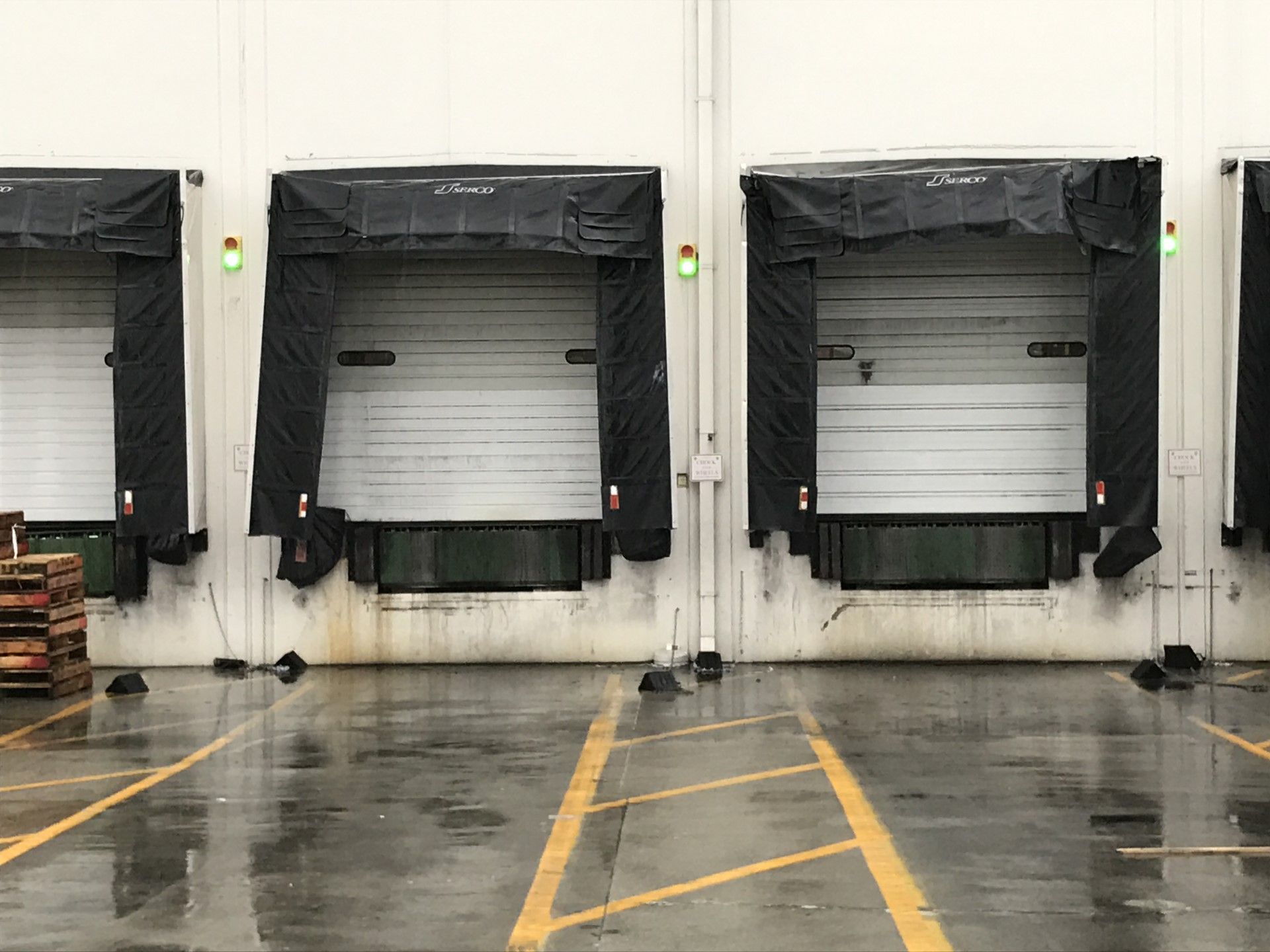 A row of loading docks in a warehouse on a rainy day.