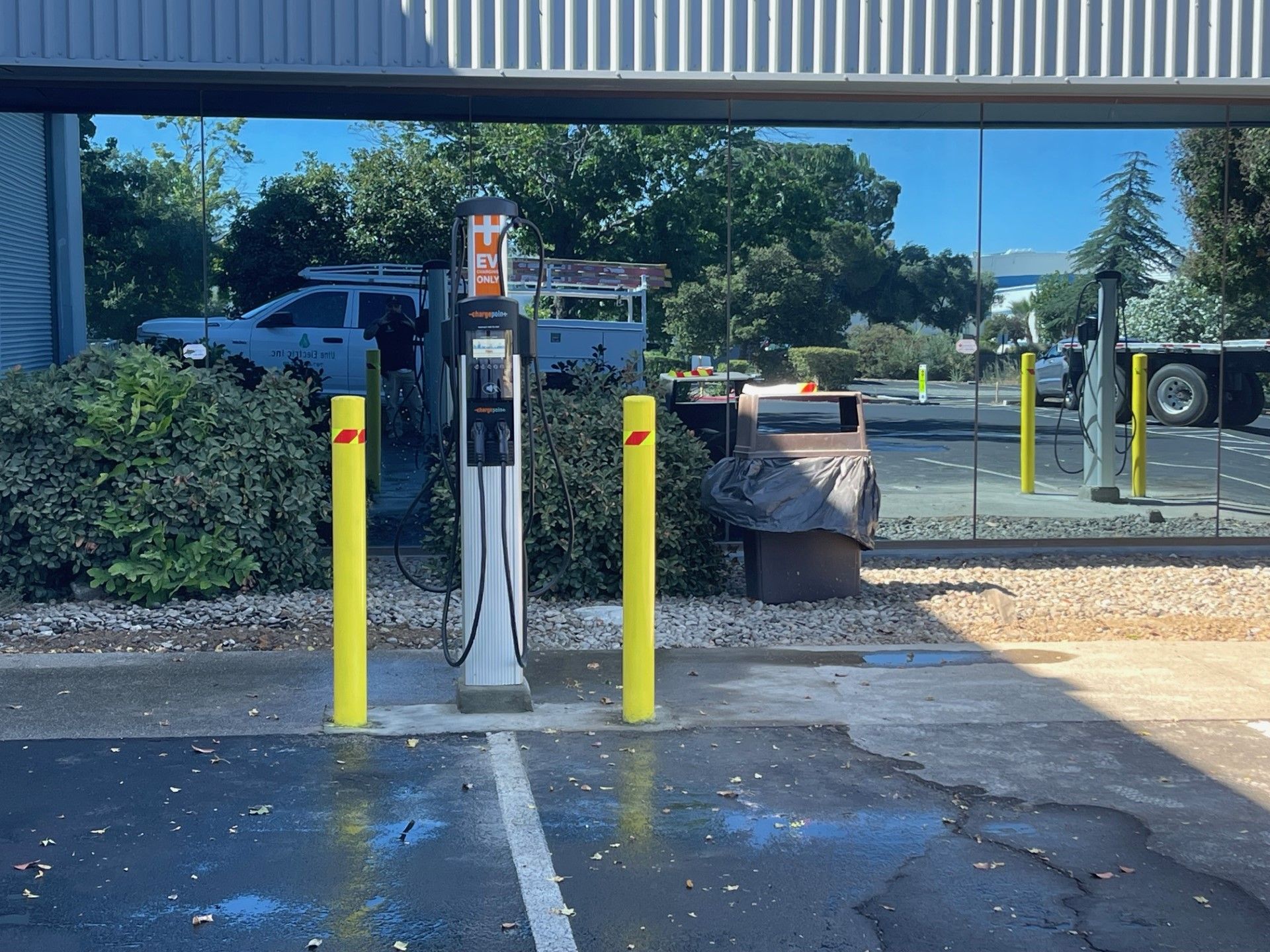 A parking lot with a gas pump and yellow poles