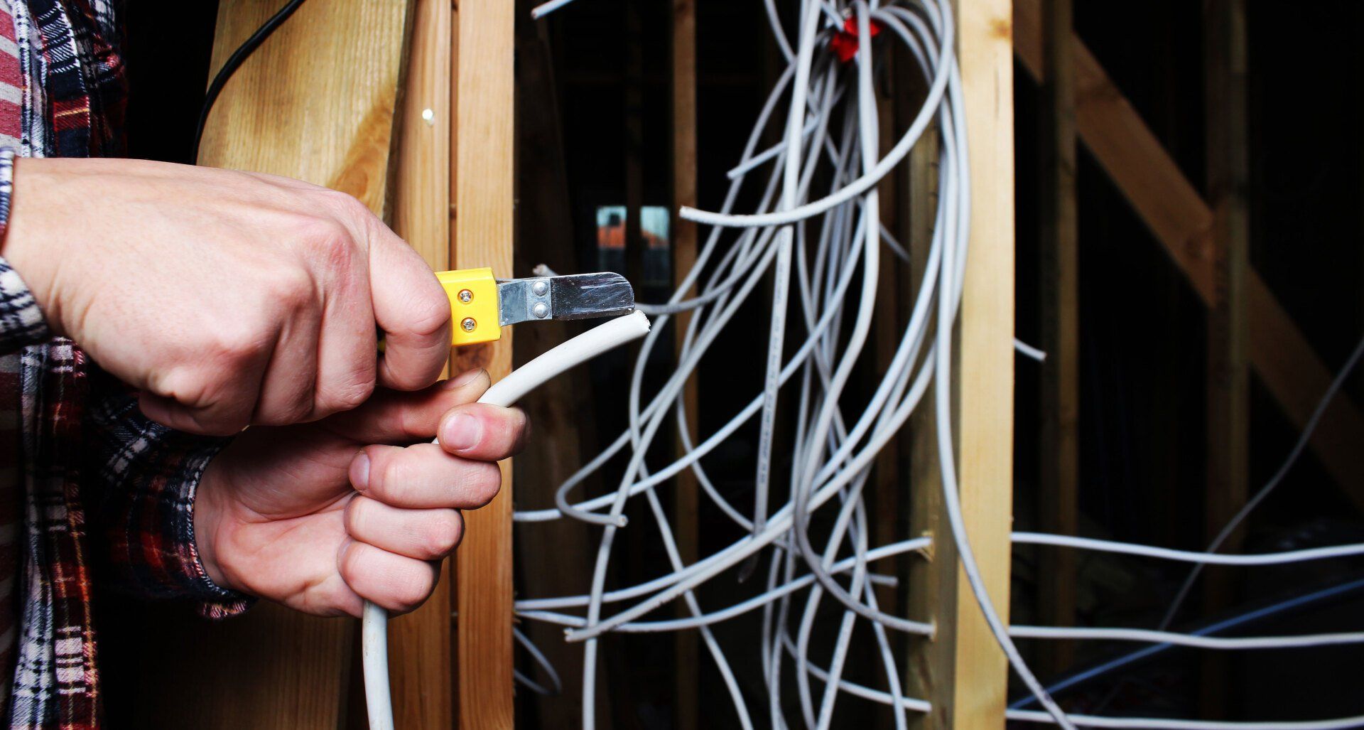 A man is cutting a wire with a pair of pliers.