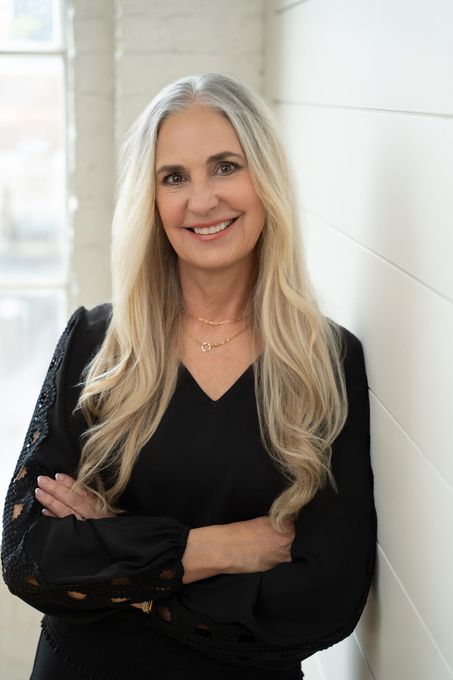 A man and a woman are sitting on a dock overlooking a lake.