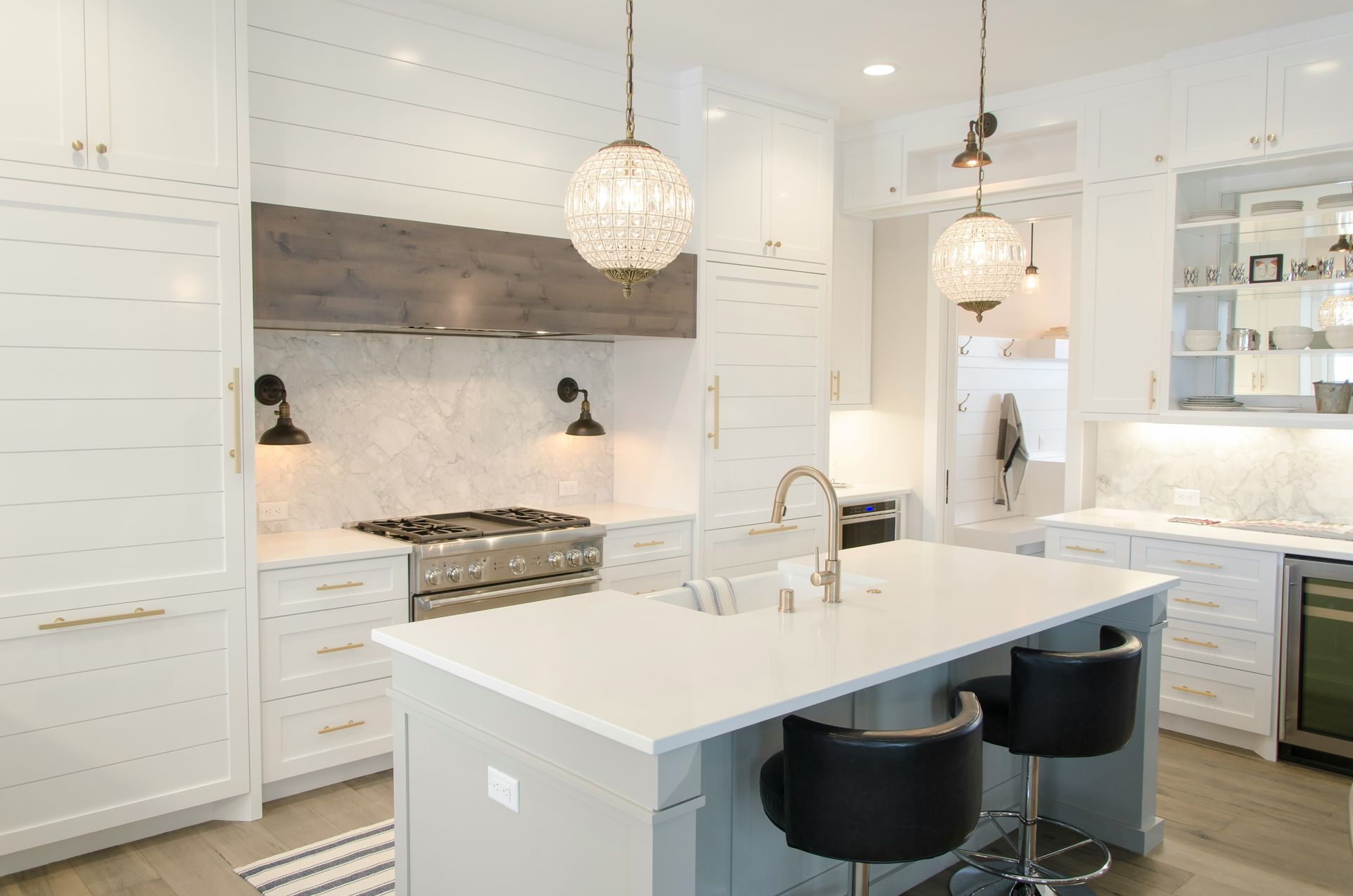 Bright white modern kitchen with island, pendant lights, and stainless steel appliances