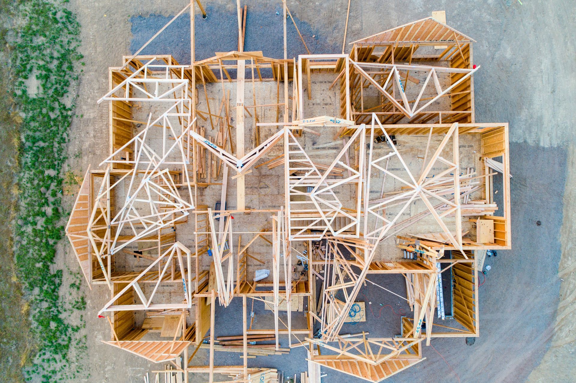 Overhead view of a house frame under construction with exposed wooden trusses and beams