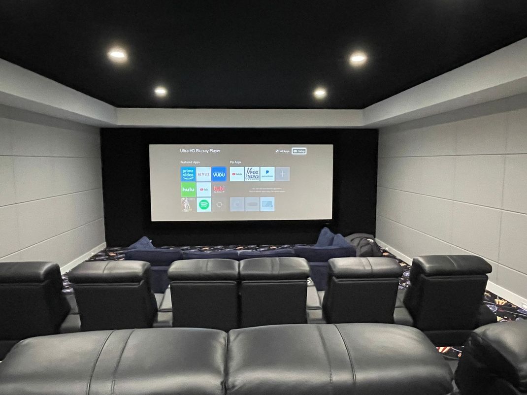 A home theater with a projector and a lot of chairs