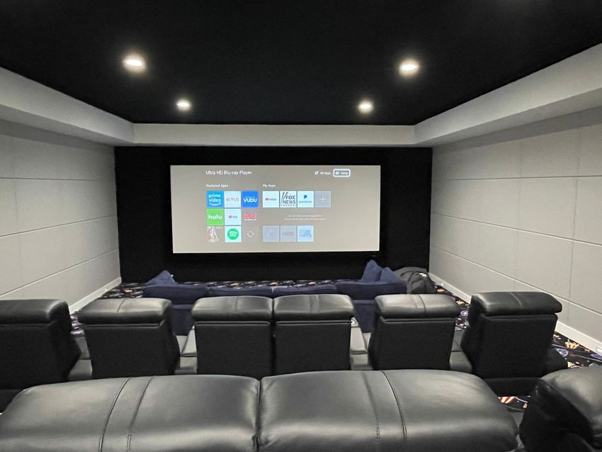 A home theater with a projector and a lot of chairs