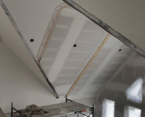 A room with a vaulted ceiling and a scaffolding in it.