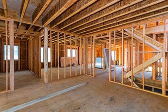 An empty room in a house under construction with wooden beams.