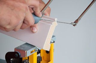 A person is cutting a piece of wood with a saw.