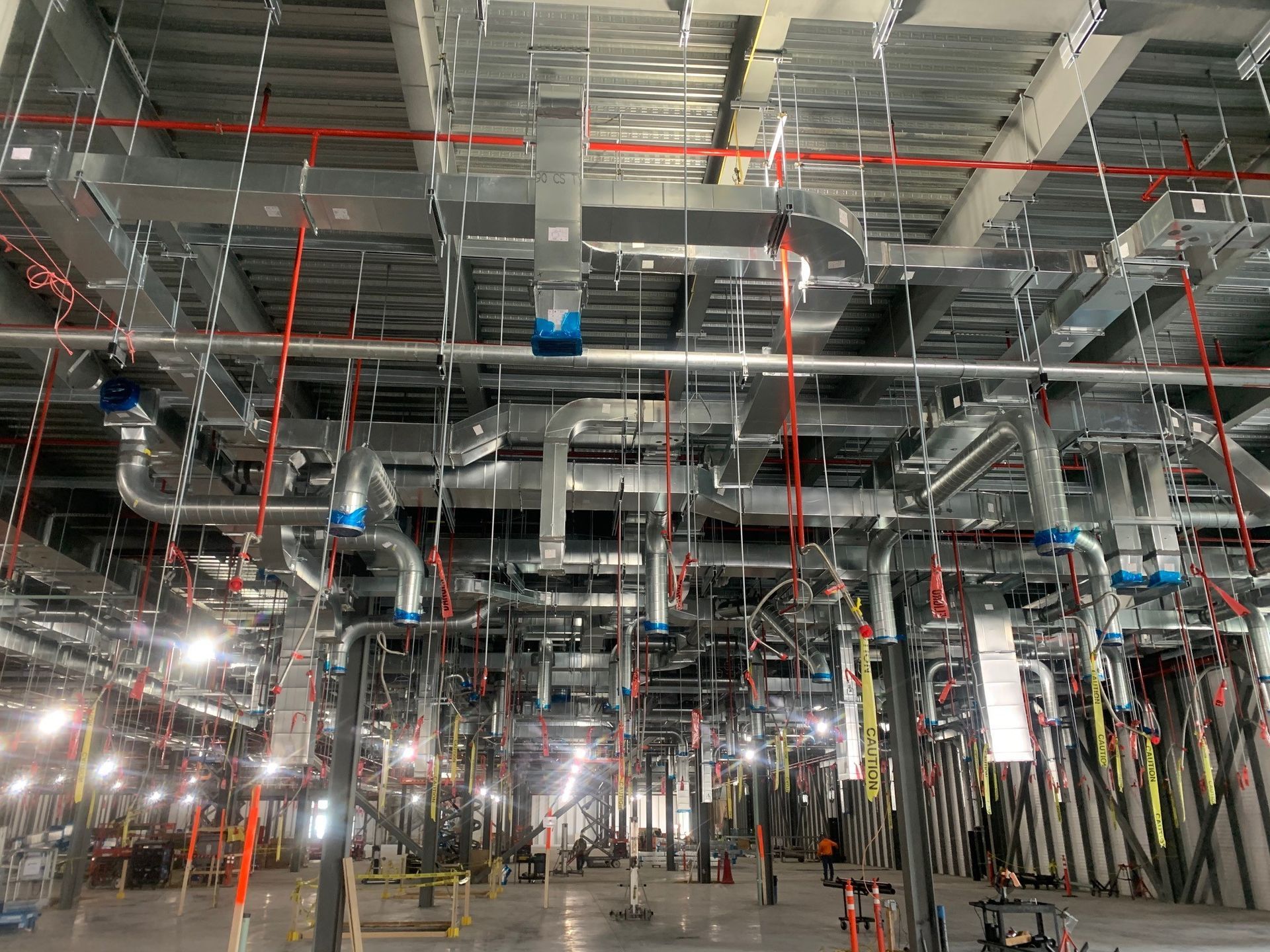 A large room with a lot of pipes hanging from the ceiling.