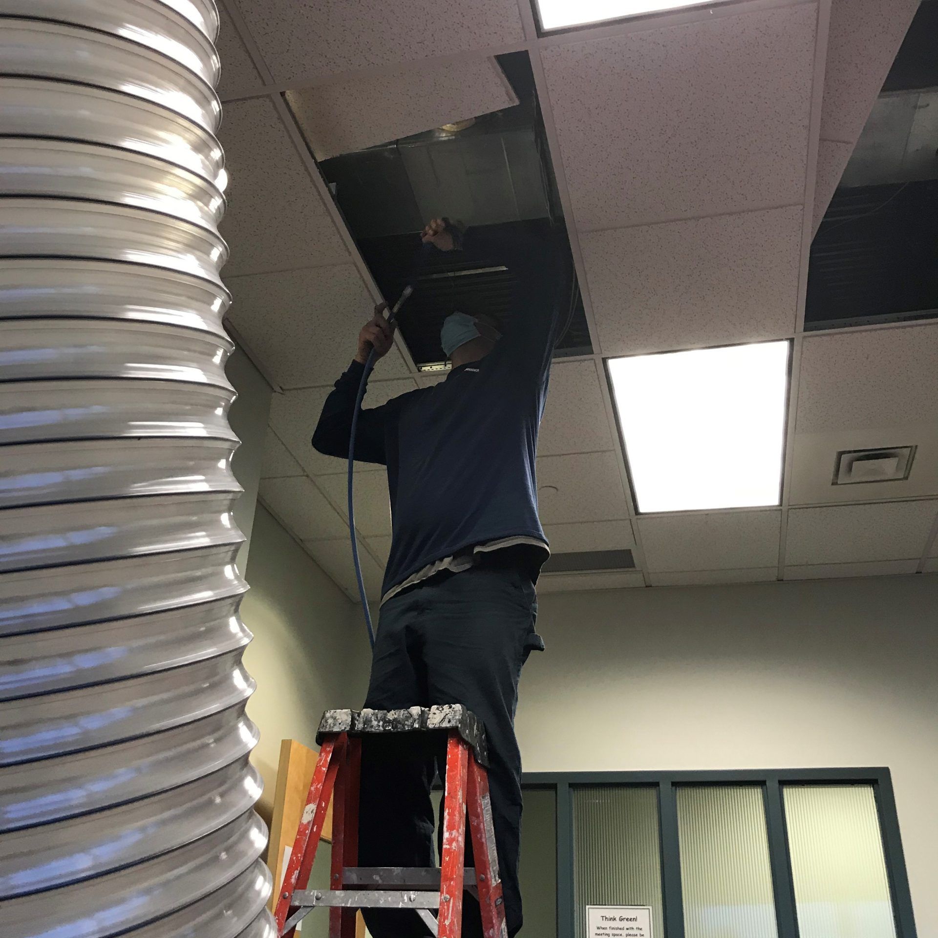 A Man on A Ladder Is Working on A Ceiling | S. Glens Falls, NY | Performance Industrial