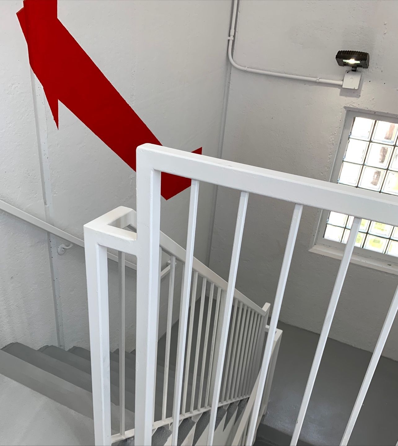 A staircase with a red arrow painted on the wall