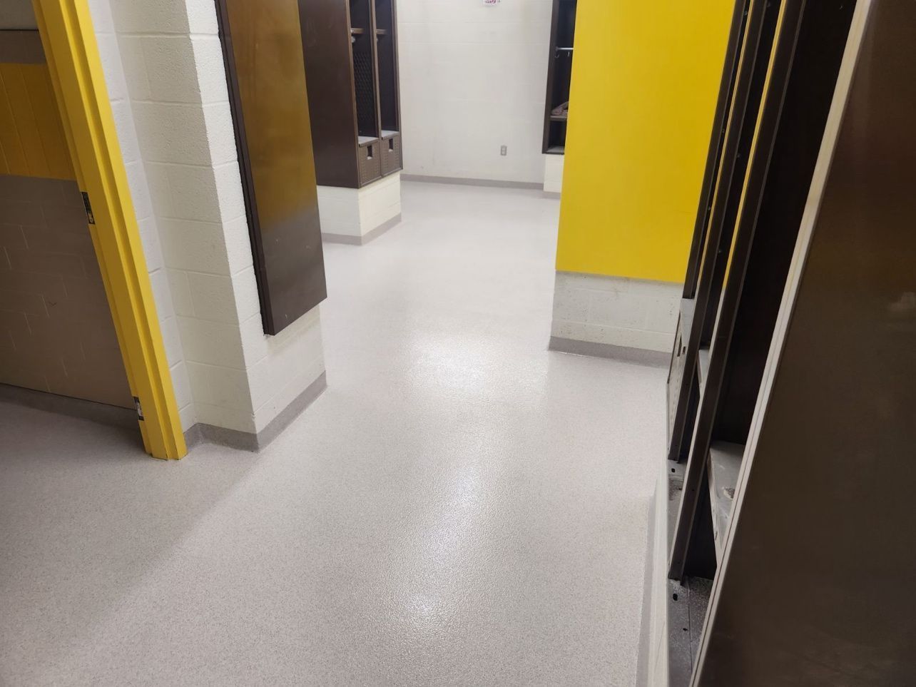A hallway with a white floor and yellow walls