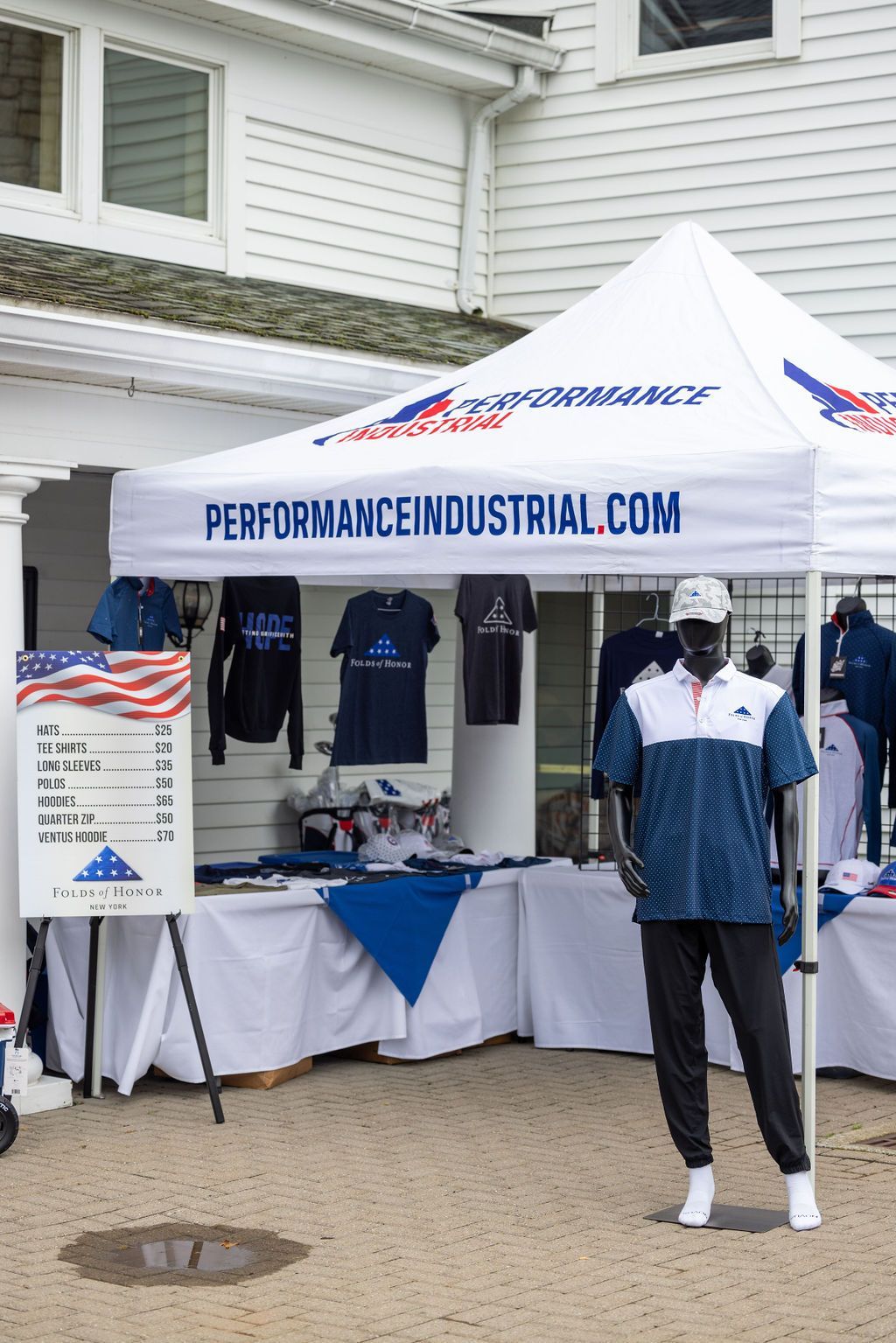 A man is standing in front of a performance industrial tent.