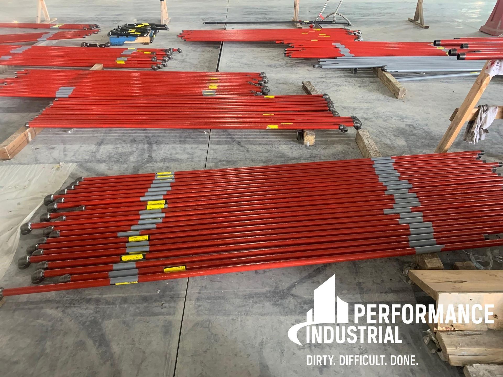 A bunch of red scaffolding in a warehouse that says performance industrial