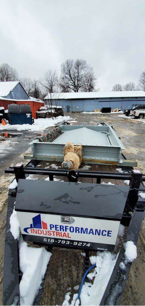 A dog is sitting on top of a machine in the snow.