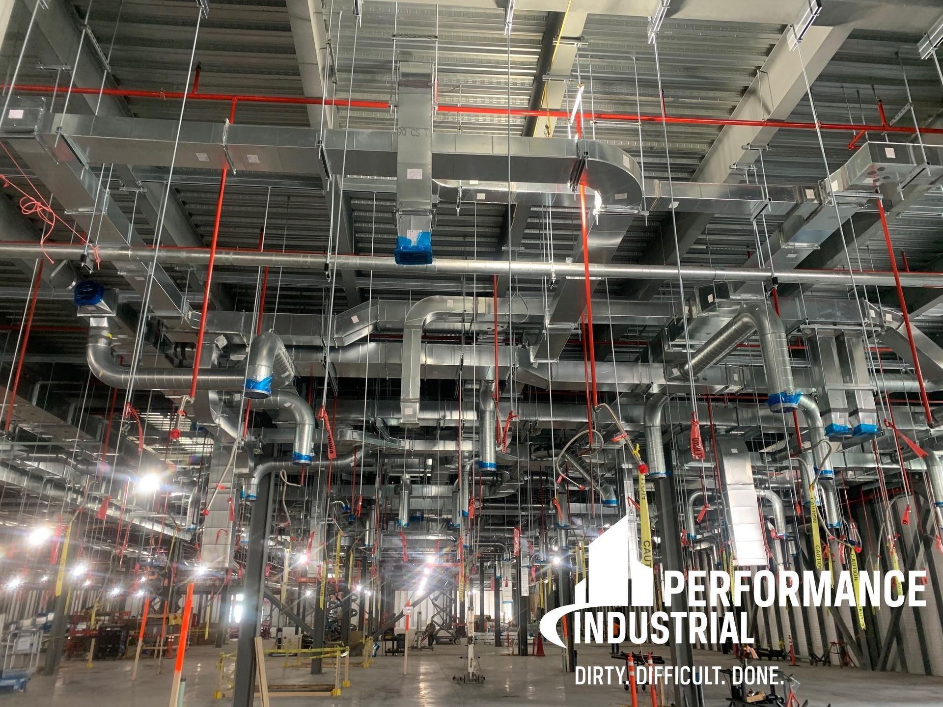 A large industrial building with a lot of pipes hanging from the ceiling.