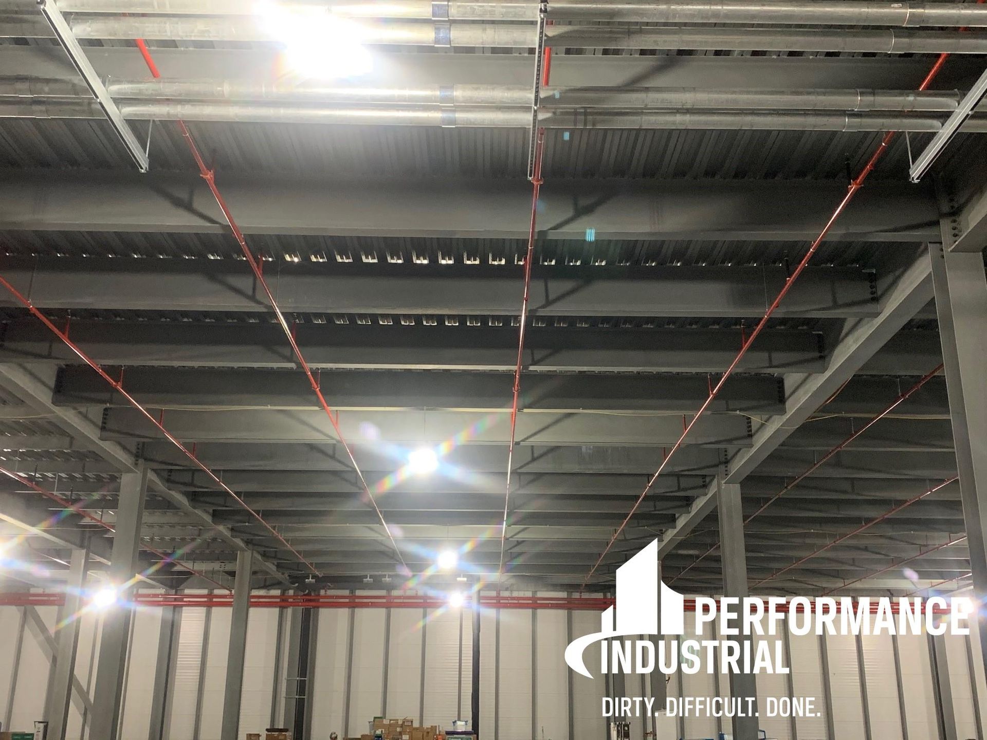 A large warehouse with a lot of lights on the ceiling.