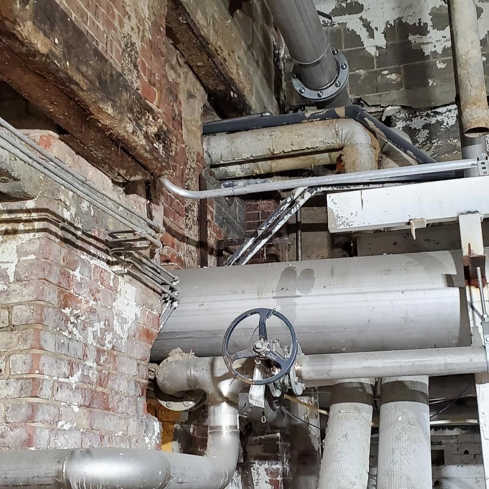 A bunch of pipes are connected to a brick wall