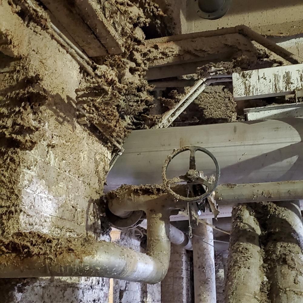 A dirty room with a lot of pipes and valves