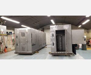 Two stainless steel containers are sitting in a warehouse.