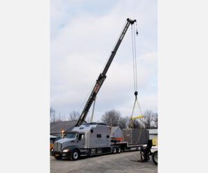 A truck with a crane attached to it is being lifted by a crane.