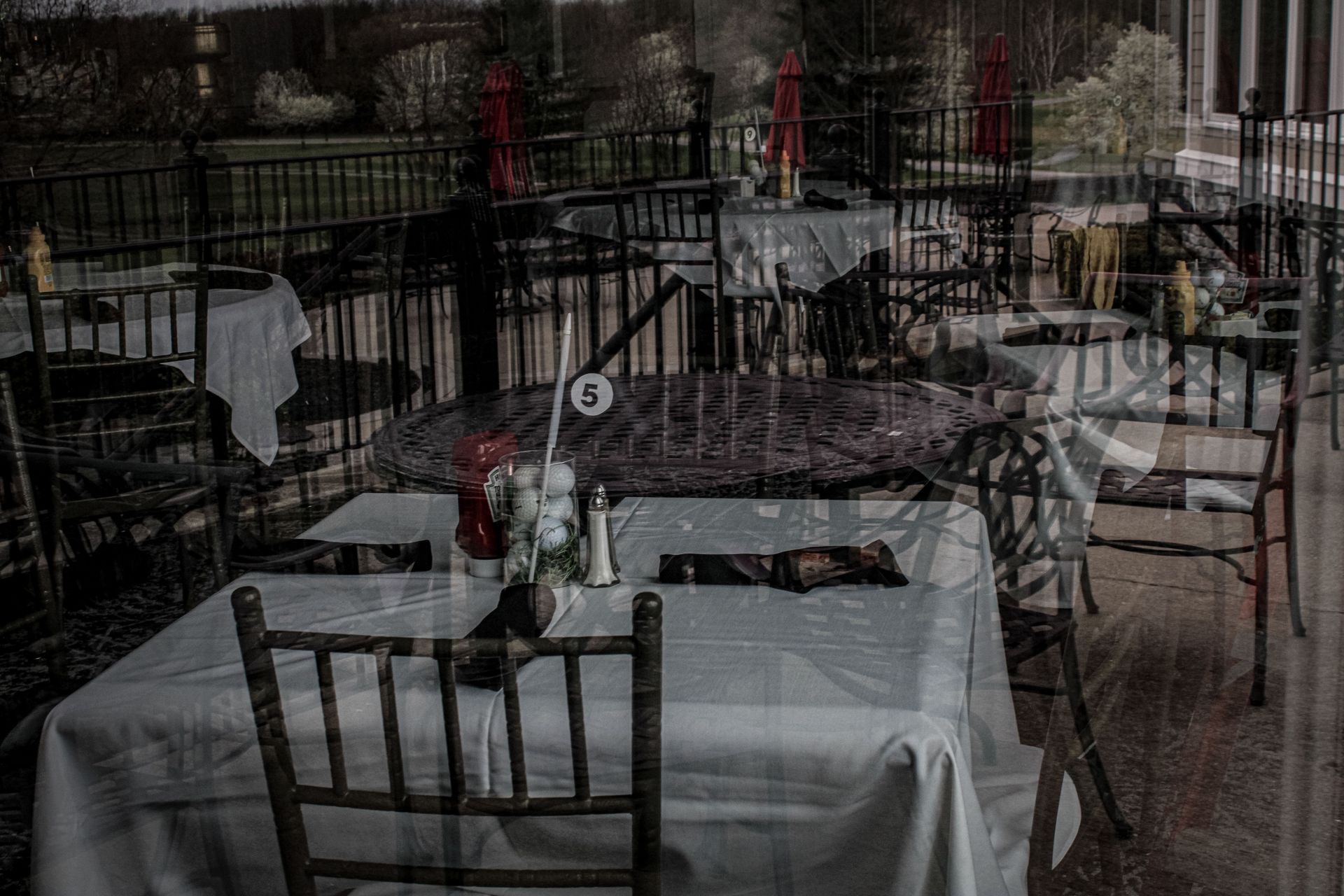A restaurant with tables and chairs set up in front of a window.