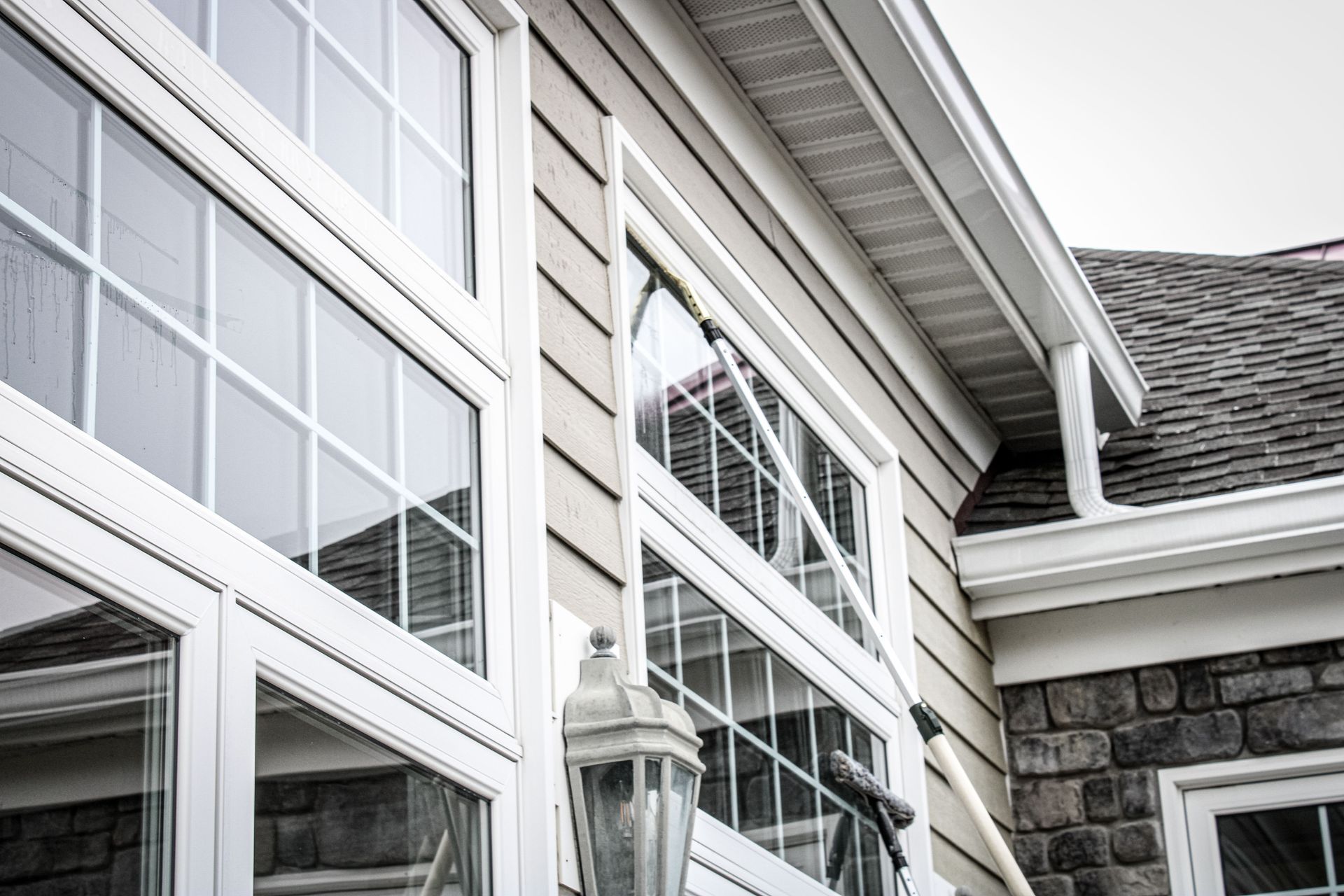 A house with a lot of windows and a lamp on the side of it.