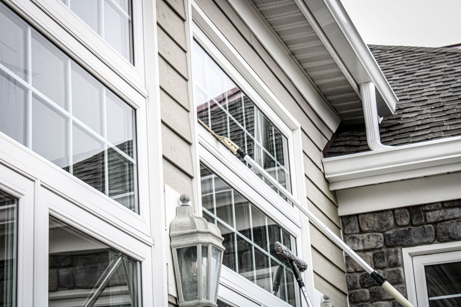 A house with a lot of windows and a lamp on the side of it.