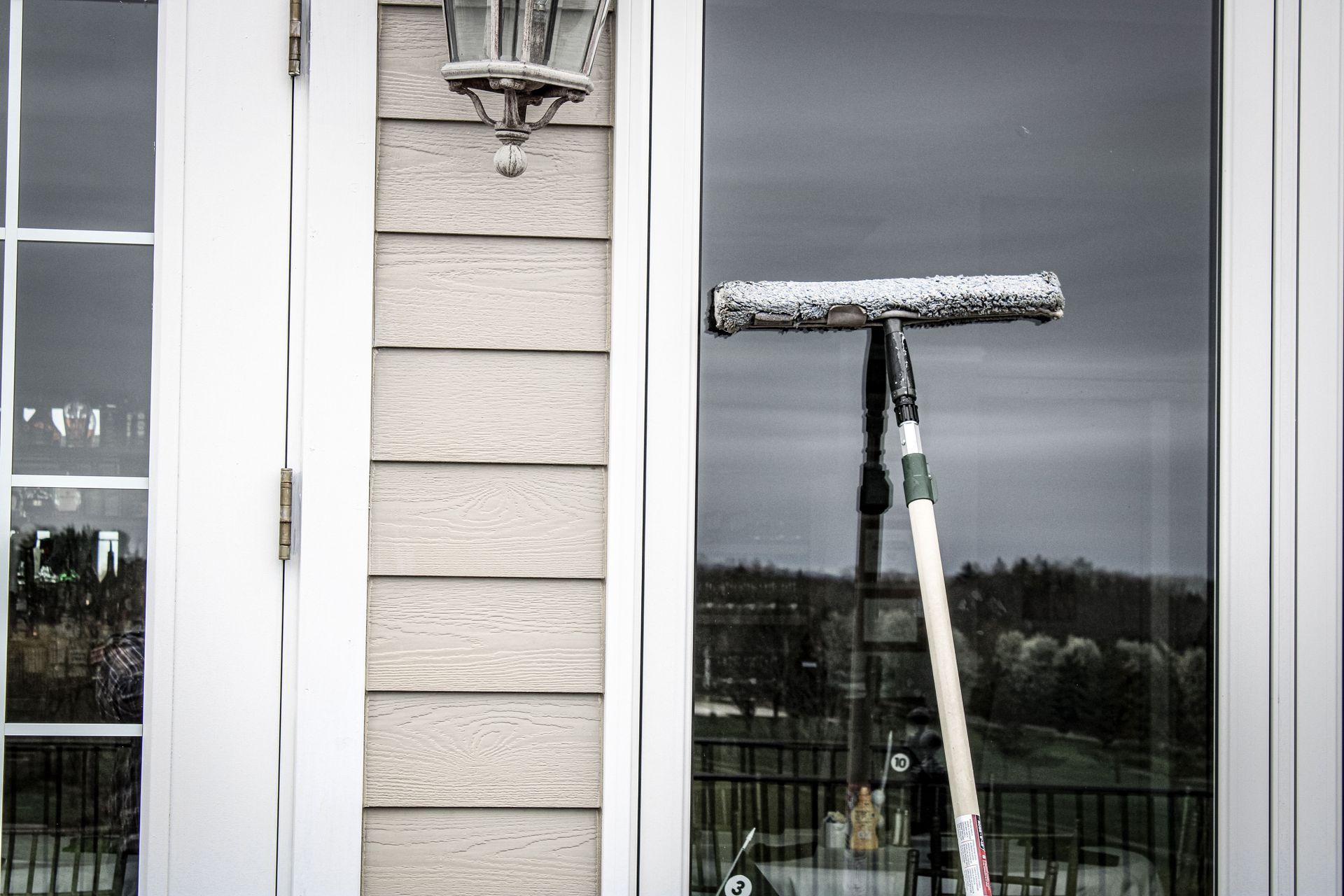 A window cleaner is cleaning a window of a house.
