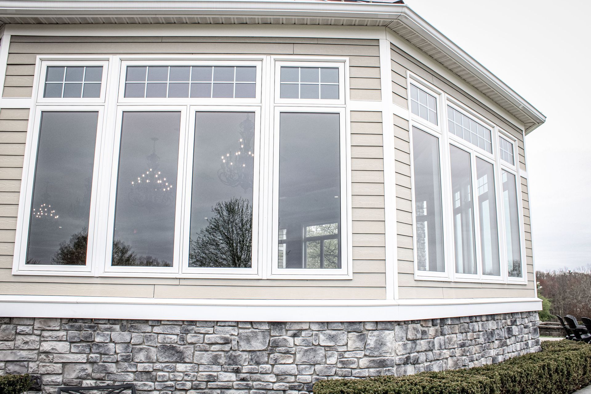 A house with a lot of windows and a stone wall