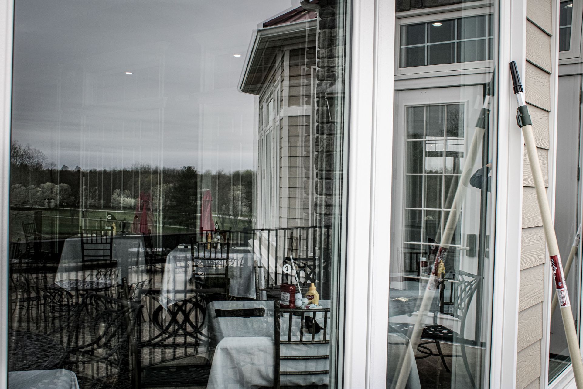A ladder is sitting on the side of a house next to a window.