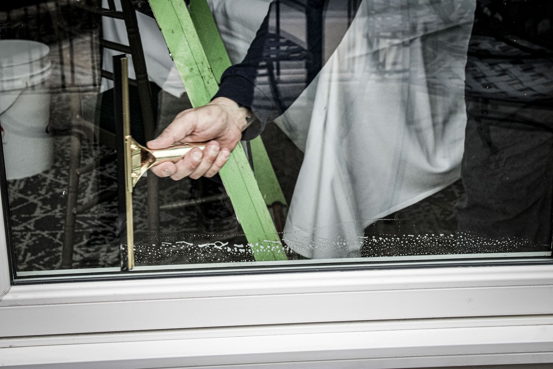 A person is cleaning a window with a brush.