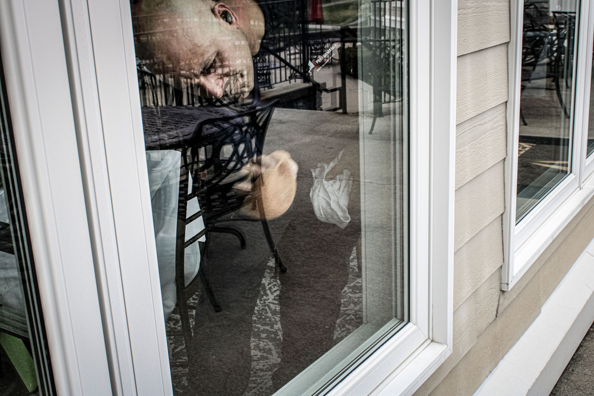 A man is looking out of a window at a dog.